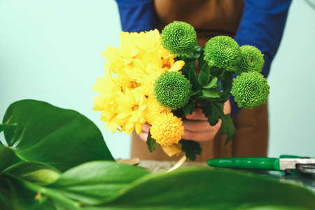 Female florist making beautiful bouquet at table