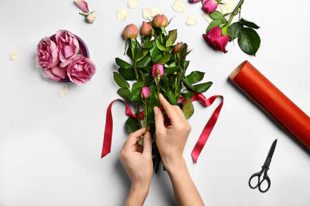Female florist making beautiful bouquet on white backgroundの写真素材