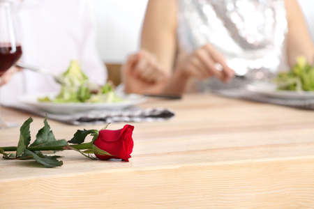 Beautiful flower on table with sitting couple on romantic date in cafeの写真素材