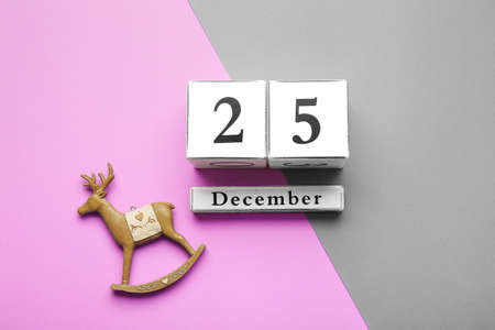 Calendar with date of Christmas on color background