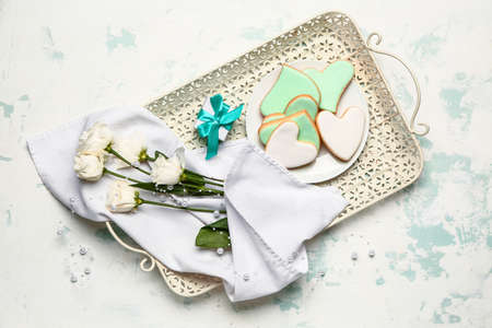 Tray with tasty heart-shaped cookies, gift and flowers on white background. Valentines Day...