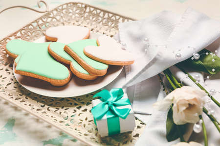 Plate with tasty heart-shaped cookies, gift and flowers on tray. Valentines Day celebration