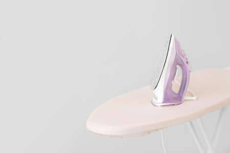 Iron on board against gray backgroundの写真素材