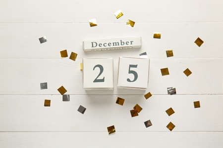 Calendar with date of Christmas and confetti on wooden backgroundの写真素材