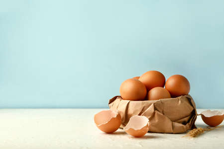 Fresh eggs on white table against color background