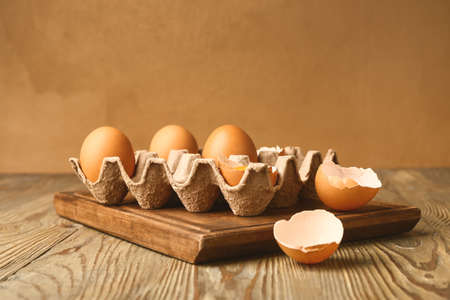 Package with fresh eggs on wooden table