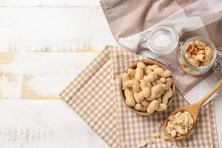 Tasty peanuts on white wooden background