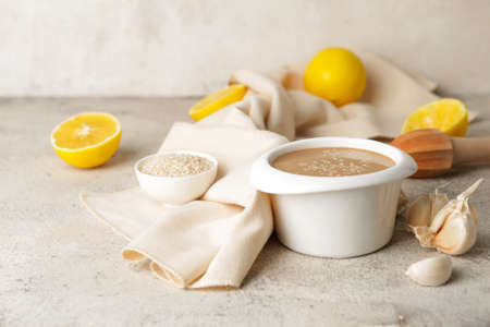 Bowl of tasty tahini on gray backgroundの写真素材