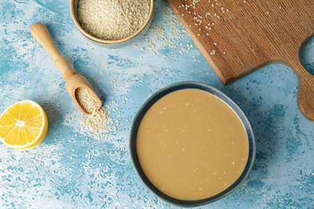 Bowl of tasty tahini on color backgroundの写真素材
