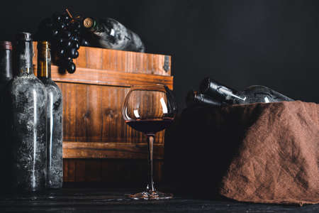 Bottles and glass of wine on table in cellarの写真素材