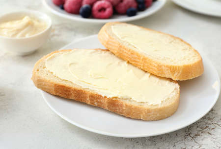 Plate with slices of bread and fresh butter on white backgroundの写真素材