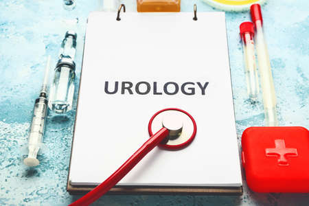 Notebook with text UROLOGY, stethoscope and medicines on color backgroundの写真素材