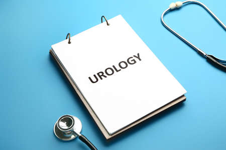 Notebook with text UROLOGY and stethoscope on color backgroundの写真素材