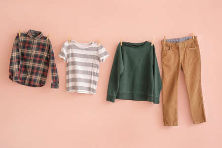 Clean laundry hanging on line against color backgroundの写真素材