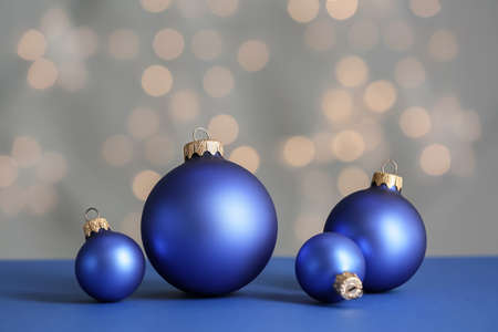 Beautiful Christmas balls on table against blurred lights