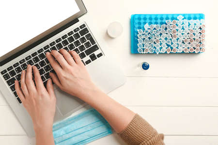 Female doctor working on laptop at table