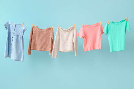 Clean laundry hanging on line against color backgroundの写真素材