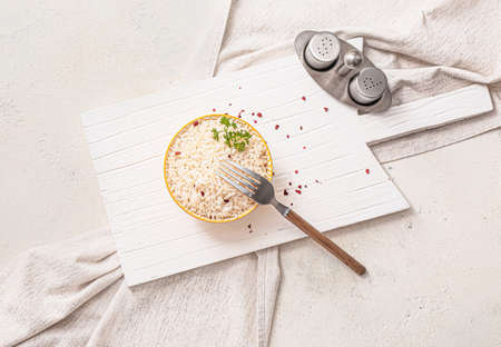 Bowl with boiled rice and spices on white backgroundの写真素材