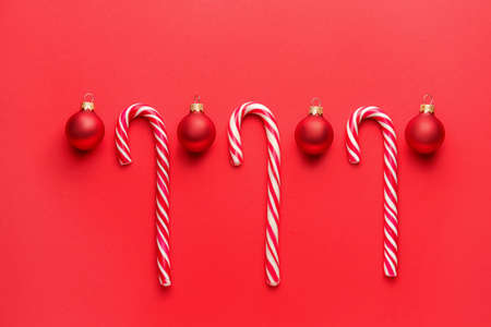 Beautiful Christmas balls with candy canes on color backgroundの写真素材