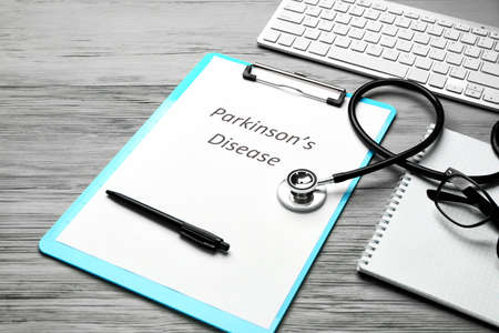 Clipboard with text PARKINSON'S DISEASE, stethoscope and computer keyboard on wooden backgroundの写真素材