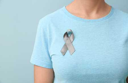 Woman with Parkinson's awareness ribbon on color background, closeupの写真素材
