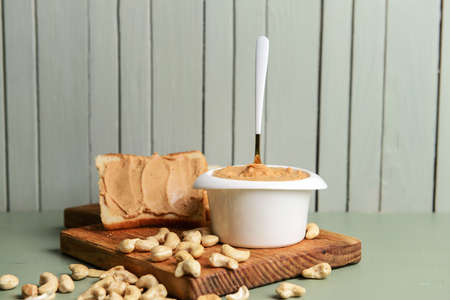 Bowl with cashew butter and bread on table