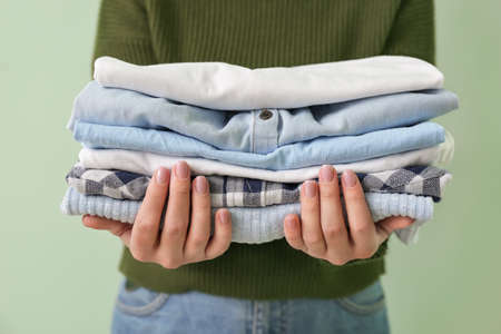 Young woman with clean clothes on color background, closeupの写真素材