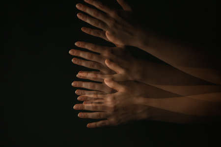Hands of woman suffering from Parkinson syndrome on dark backgroundの写真素材