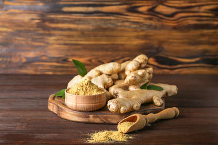 Fresh and ground ginger on wooden tableの写真素材
