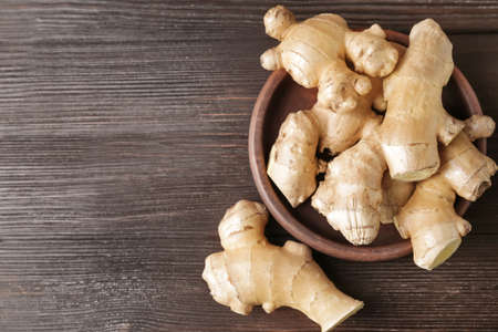Plate with fresh ginger on wooden tableの写真素材