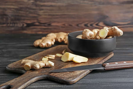 Cutting board with fresh ginger on wooden tableの写真素材