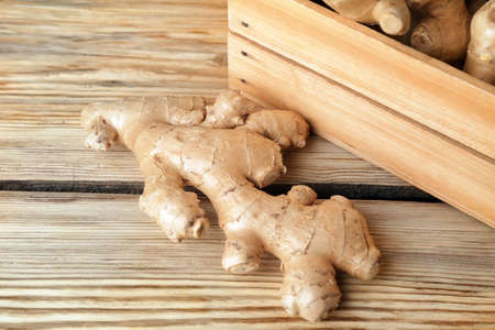 Box with fresh ginger on wooden table