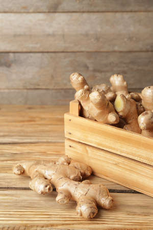 Box with fresh ginger on wooden table