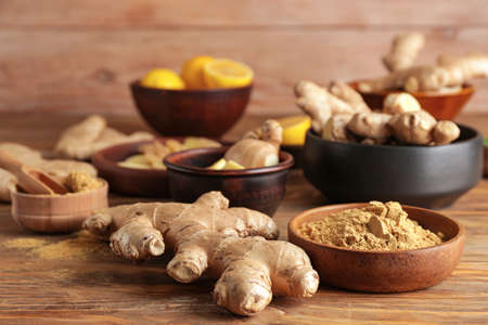 Fresh and ground ginger on wooden table