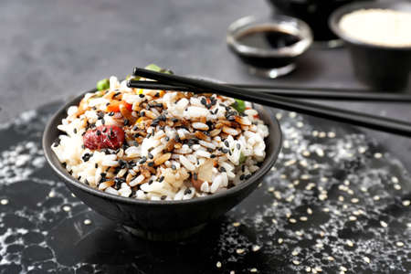 Boiled rice with vegetables in bowl on tableの写真素材
