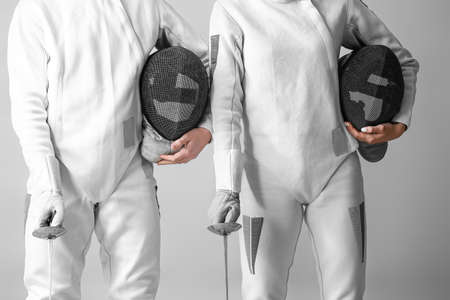 Young fencers on light background