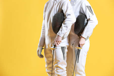 Young fencers on color background