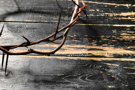 Wreath of thornes on dark wooden background, closeup