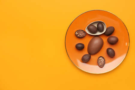 Plate with chocolate Easter eggs on color backgroundの写真素材