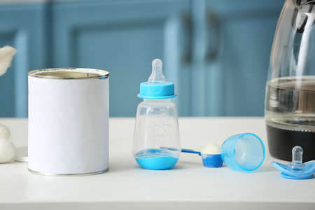 Bottle with baby milk formula on table indoorsの写真素材