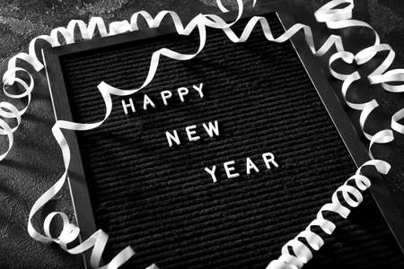 Board with text HAPPY NEW YEAR on dark backgroundの写真素材