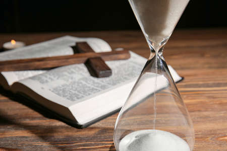 Hourglass, Bible and cross on wooden backgroundの写真素材