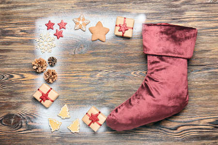 Christmas sock with gifts on wooden background