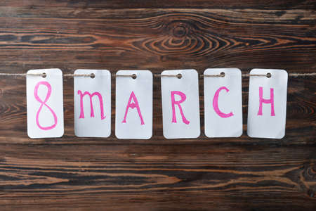 Garland for International Women's Day against wooden background