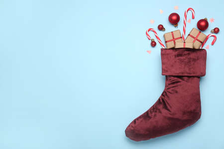 Christmas sock with gifts on color backgroundの写真素材