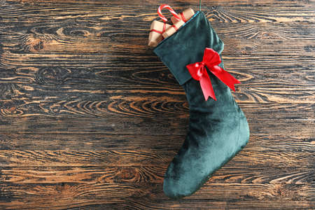 Christmas sock with gifts on wooden backgroundの写真素材
