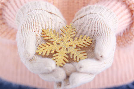 Woman with knitted gloves and snowflake, closeupの写真素材