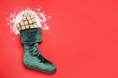 Christmas sock with gifts on color backgroundの写真素材