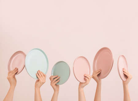 Hands with different clean plates on color backgroundの写真素材