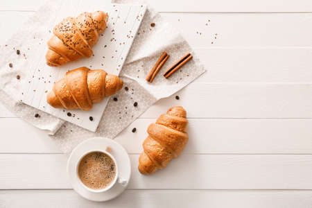 Tasty croissants and cup of coffee on tableの写真素材